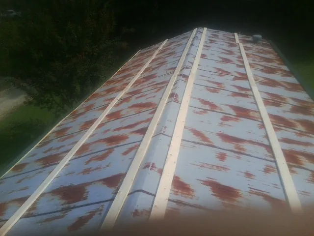 Rusted metal roof panels with new wood purlins before replacement — Storm Damage Roof Repair in Traverse City by Roofing Brothers