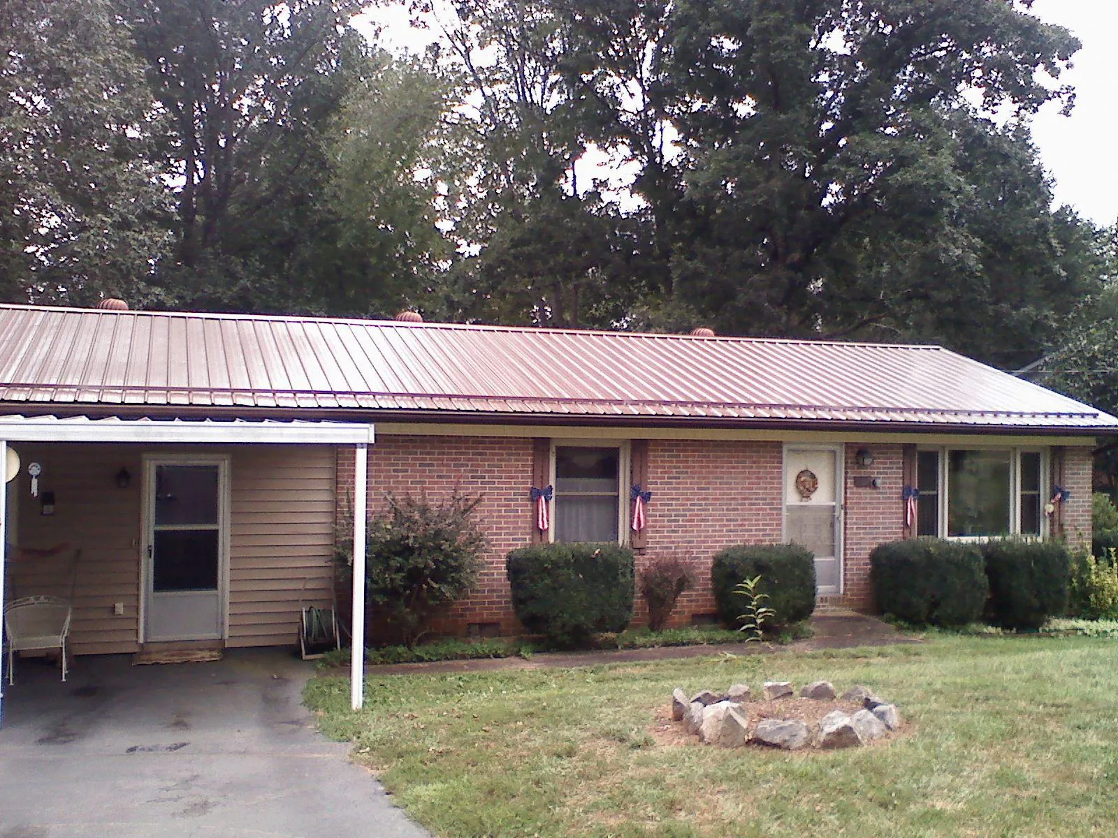 Bronze metal roof and carport on a brick ranch home — Roof Repair work by our crew in Traverse City